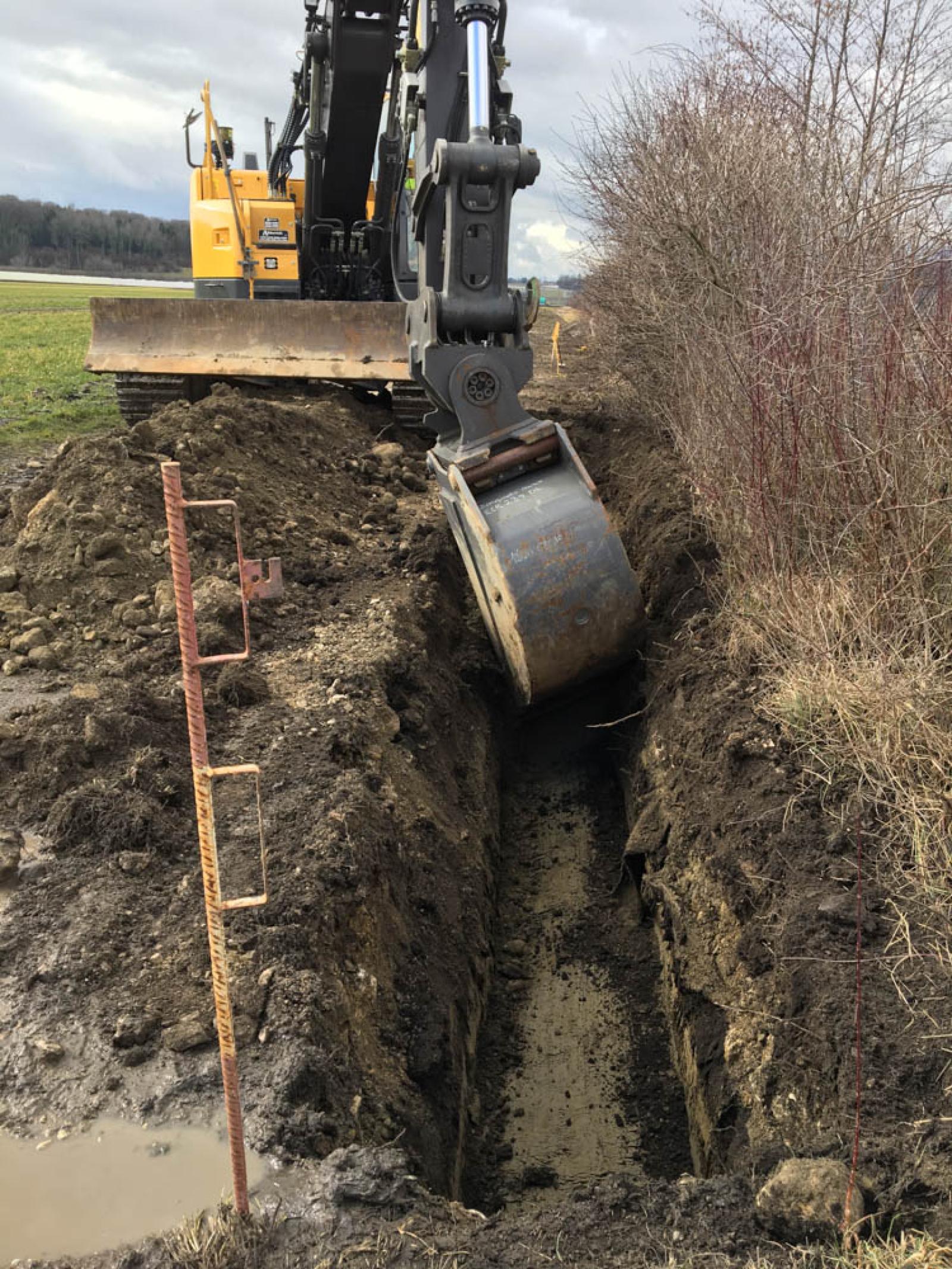 Travaux de creusement d'une tranchée entre le chemin agricole et le talus