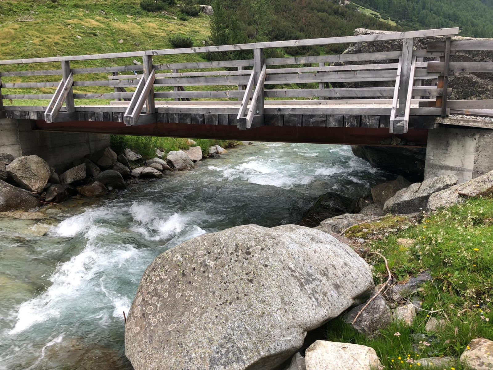 Pont sur un ruisseau de montagne avec de grandes pierres des deux côtés (© Christof Angst)