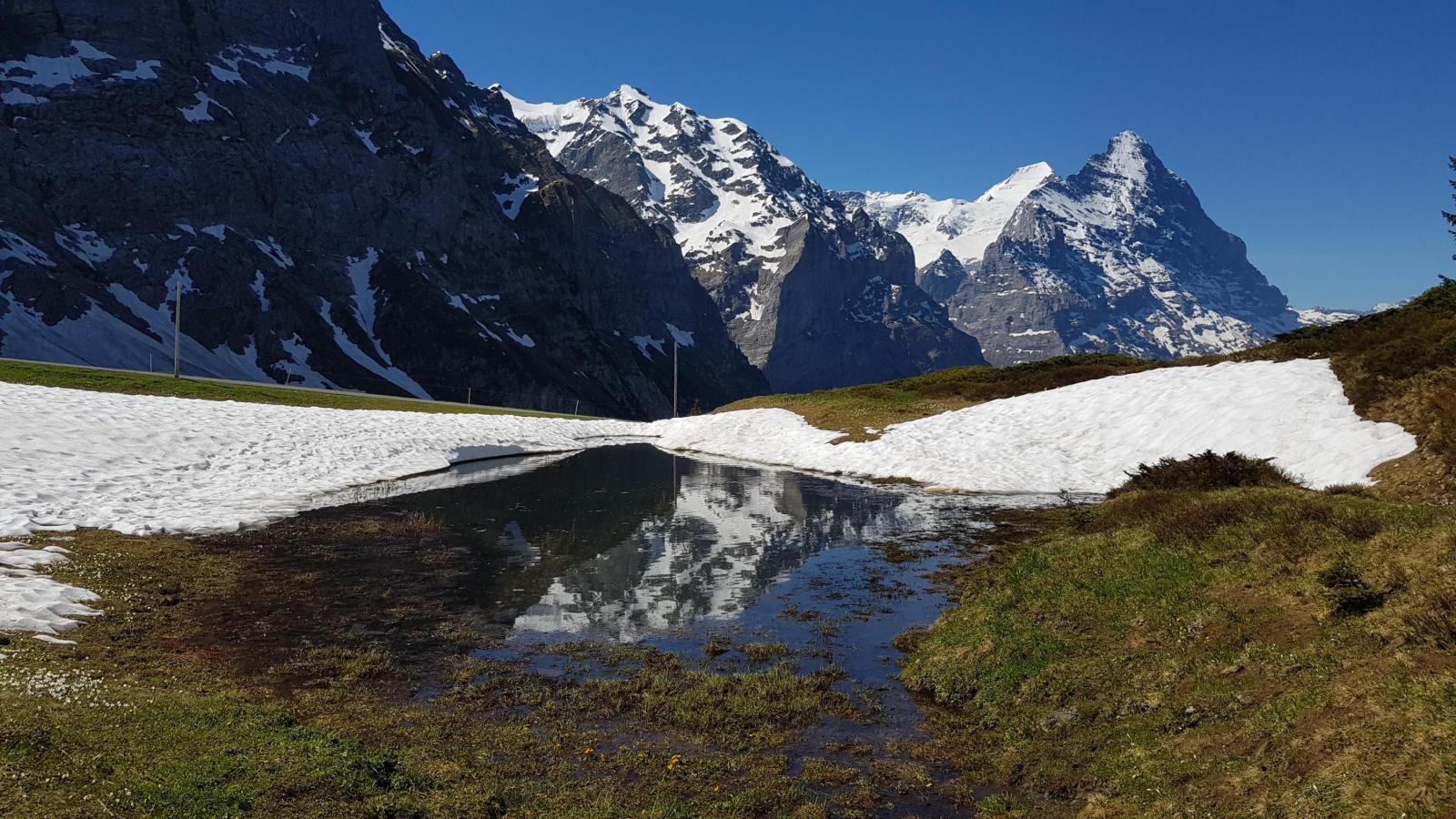 Lac de montagne avec de la neige sur les rives par temps ensoleillé