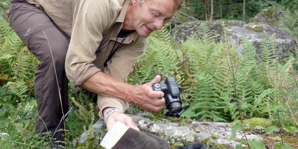 Jean-Claude Monney en train de photographier un serpent